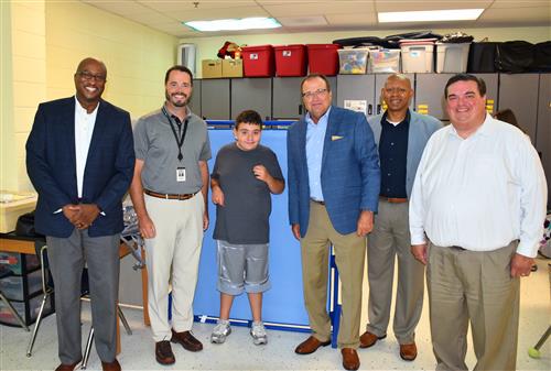 Board members and Dr. Nichols with student in a classroom